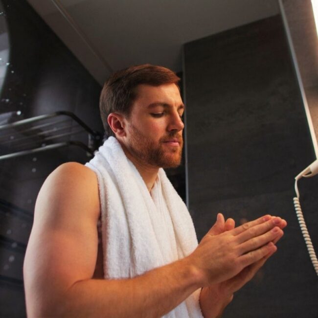 Homme qui applique de la crème entre ses doigts